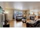 Cozy living room featuring hardwood floors, a fireplace, comfortable seating, and a view of the snow-covered outdoors at 1150 W 127Th Ct, Denver, CO 80234