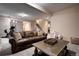 Spacious finished basement with a brown leather couch, stairs, and stylish decor at 1334 Solitude Ln, Evergreen, CO 80439