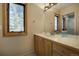 Bathroom with vanity, wood cabinets, and a window showcasing scenic outdoor views at 1334 Solitude Ln, Evergreen, CO 80439