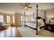 Spacious main bedroom with four-poster bed, hardwood floors, and windows showcasing scenic outdoor views at 1334 Solitude Ln, Evergreen, CO 80439