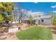 Expansive backyard with artificial turf, patio area, detached garage, and mature trees at 3485 S Forest St, Denver, CO 80222