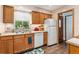 Bright kitchen featuring updated appliances, wood cabinets, and seamless flow into the adjacent dining and living area at 3485 S Forest St, Denver, CO 80222