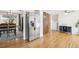 Bright kitchen featuring stainless steel refrigerator, hardwood floors, and connection to the dining area at 214 N 10Th Ave, Brighton, CO 80601