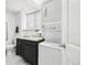 Functional laundry room equipped with stacked washer and dryer, a sink and white walls at 214 N 10Th Ave, Brighton, CO 80601