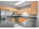 Modern kitchen with stainless steel appliances, sleek countertops, and natural wood cabinetry at 1780 N Washington St # 405, Denver, CO 80203