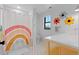 Bright bathroom featuring rainbow shower curtain, tiled floor, and playful floral decor at 501 Lois Dr, Louisville, CO 80027