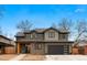 Charming two-story home showcasing neutral siding, a black garage door, and a cozy covered porch at 501 Lois Dr, Louisville, CO 80027