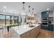 Modern kitchen showcases an island with sink, stainless appliances, and a view to the outdoor dining at 501 Lois Dr, Louisville, CO 80027