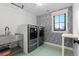 Well-appointed laundry room with modern appliances, bright wallpaper, and a convenient sink at 501 Lois Dr, Louisville, CO 80027