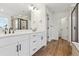 Modern bathroom with dual sinks, white cabinets, sleek fixtures, and walk-in shower at 8230 Snake River St, Littleton, CO 80125