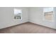 Bright bedroom features neutral carpet, white walls, and windows offering natural light at 8230 Snake River St, Littleton, CO 80125