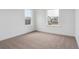Bright bedroom features neutral carpet, white walls, and windows offering natural light at 8230 Snake River St, Littleton, CO 80125