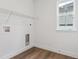 Practical laundry room features sleek wood floor, a window, and overhead shelving at 8230 Snake River St, Littleton, CO 80125