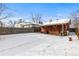 Snowy backyard features a covered patio, wooden fence, and plenty of space at 4518 Vallejo St, Denver, CO 80211