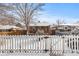 Cute home surrounded by a charming white picket fence and a yard dusted with snow at 4518 Vallejo St, Denver, CO 80211