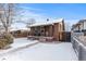 Charming brick home with a cozy front porch and snow-covered yard at 4518 Vallejo St, Denver, CO 80211