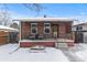 Charming brick home showcases an inviting front porch with seating and classic details at 4518 Vallejo St, Denver, CO 80211