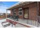 Charming front porch of a brick home with wrought iron railings, perfect for enjoying winter days at 4518 Vallejo St, Denver, CO 80211