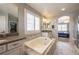 Luxurious bathroom featuring a soaking tub, double vanity with tile accents and a walk-in closet for an organized design at 190 Olympia Ave, Longmont, CO 80504