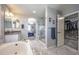 Elegant bathroom with a soaking tub, glass-enclosed shower, dual sinks, and access to a walk-in closet and bedroom at 190 Olympia Ave, Longmont, CO 80504