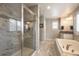 Modern bathroom boasts a glass-enclosed shower, a soaking tub, and elegant tilework that enhances the spa-like atmosphere at 190 Olympia Ave, Longmont, CO 80504