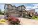 Charming two-story home featuring stone accents, a covered porch, and a well-manicured front yard with colorful flower beds at 190 Olympia Ave, Longmont, CO 80504
