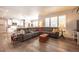 Spacious living room featuring hardwood floors, a large sectional sofa, and access to kitchen at 190 Olympia Ave, Longmont, CO 80504