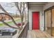 Balcony view with wooden floors, a red door, and gas bottle offering a cozy outdoor space at 6388 Oak Ct # 203, Arvada, CO 80004