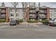 Exterior view of the apartments with a parking lot and landscape with trees and bushes at 6388 Oak Ct # 203, Arvada, CO 80004