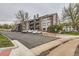 View of the apartment with parking lot and landscape trees and bushes at 6388 Oak Ct # 203, Arvada, CO 80004
