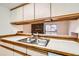 Convenient double sink is set into a counter with open shelving, overlooking the Gathering room at 6388 Oak Ct # 203, Arvada, CO 80004
