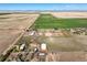 Aerial view of a farm or ranch nestled amid vast fields, showing the house, barn, and surrounding landscape at 29881 E 128Th Ave, Commerce City, CO 80022