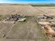 Expansive aerial view of a farm property featuring agricultural fields, multiple buildings, horse enclosure, and barns at 29881 E 128Th Ave, Commerce City, CO 80022