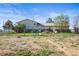 The large backyard is fenced, featuring a well-maintained lawn, mature tree, and a patio area with grill at 29881 E 128Th Ave, Commerce City, CO 80022