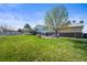 Spacious backyard featuring a well-maintained lawn, mature tree, and a patio area, perfect for outdoor entertaining at 29881 E 128Th Ave, Commerce City, CO 80022