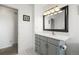 A bathroom with gray cabinets, a quartz countertop, white walls, and white tile flooring at 29881 E 128Th Ave, Commerce City, CO 80022