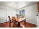 A dining room has a wood floor, table, chairs, and a window with outdoor views at 29881 E 128Th Ave, Commerce City, CO 80022