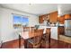 A naturally lit dining room is furnished with a wooden table, chairs, and wood flooring at 29881 E 128Th Ave, Commerce City, CO 80022