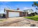 Brick and Vinyl home featuring a spacious garage, long driveway and well manicured lawn at 29881 E 128Th Ave, Commerce City, CO 80022