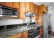 This kitchen features wood cabinets, granite countertops, stainless steel appliances, and a modern range at 29881 E 128Th Ave, Commerce City, CO 80022