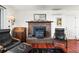 Inviting living room with hardwood floors, brick fireplace, a vintage-inspired decor at 29881 E 128Th Ave, Commerce City, CO 80022