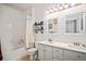 Well-lit bathroom with a double sink vanity, bathtub with shower, and modern fixtures at 8358 S Independence Cir # 105, Littleton, CO 80128