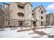 Exterior view of a multi-story building with stone accents and snowy landscape at 8358 S Independence Cir # 105, Littleton, CO 80128