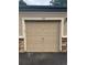 Attached single-car garage featuring paneled door and stone accents on a well-maintained home exterior at 8358 S Independence Cir # 105, Littleton, CO 80128