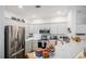 Well-lit kitchen featuring white cabinetry, stainless steel appliances, and a breakfast bar, perfect for modern living at 8358 S Independence Cir # 105, Littleton, CO 80128