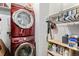 Efficient laundry room featuring stacked washer and dryer, cabinet storage and convenient shelving at 8358 S Independence Cir # 105, Littleton, CO 80128