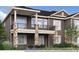 Multi-story home with covered balconies, stone pillars, and lush landscaping, offering attractive curb appeal at 935 W 128Th Pl, Westminster, CO 80234