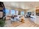 Open concept living room featuring plenty of natural light, modern decor, and a view into the dining and kitchen areas at 935 W 128Th Pl, Westminster, CO 80234