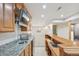 Finished basement featuring a wet bar with a sink, stainless steel microwave and granite countertops at 2660 Timberchase Trl, Highlands Ranch, CO 80126