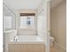Bathroom featuring a soaking tub with a window, a tiled surround, and a glass shower at 2660 Timberchase Trl, Highlands Ranch, CO 80126